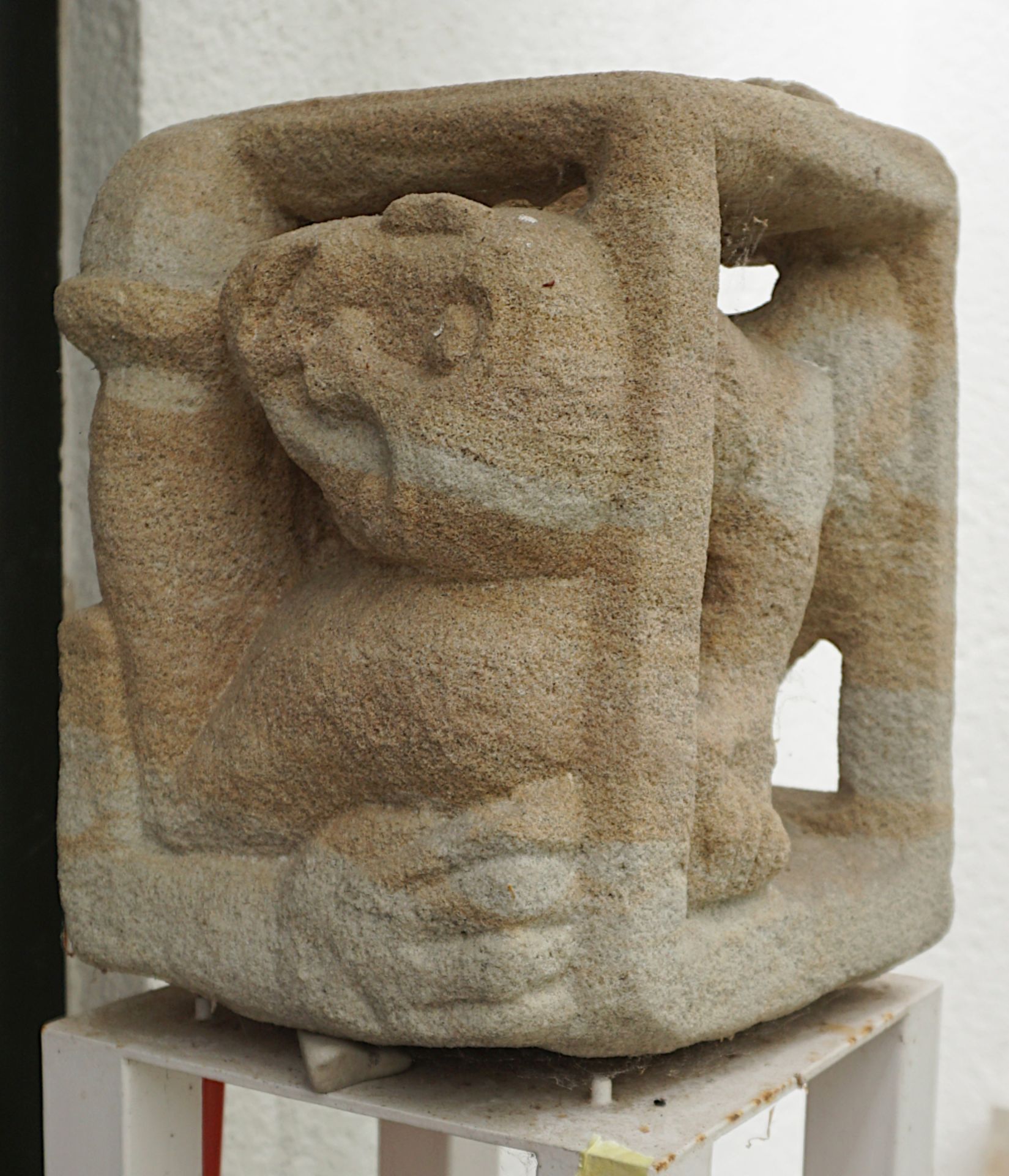 1 Steinfigur "Ausbrechen", ca. 31cm x 26cm, auf vierkantigem Eisensockel, Asp.