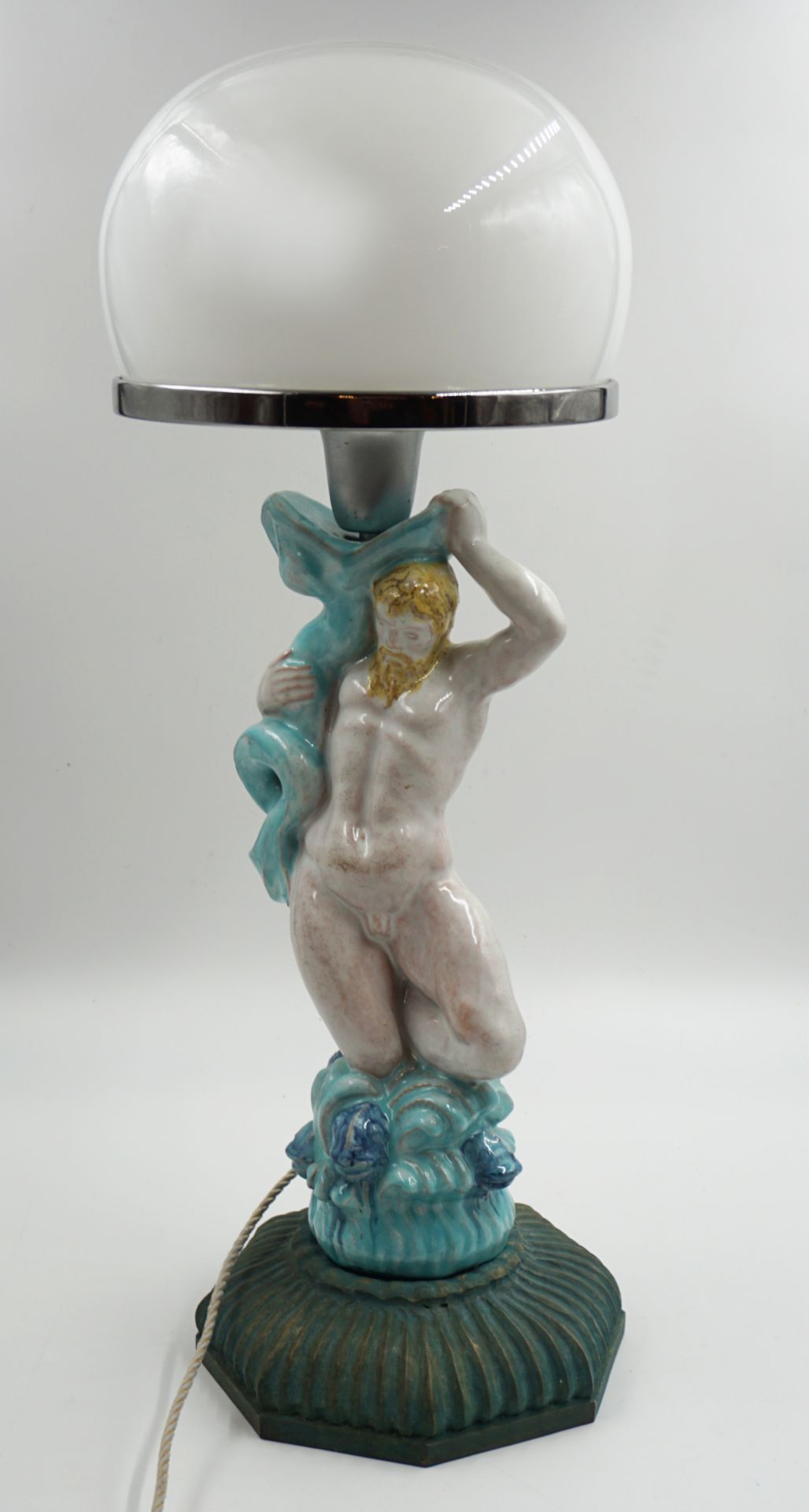 1 Tischlampe bemalte Keramik mit Holzsockel und Glasschirm "Triton mit Delphin" ca. H 59cm, ber, Asp
