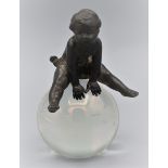 Fast unbekleidetes Kind auf einer Glaskugel, Miniatur-Skulptur um 1920, mundgeblasene Glaskugel mit