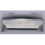 An Arts and Crafts silver rectangular table cigar box, shaped strap hinges, stylised bud feet,