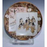A Japanese Kutani pottery circular charger, painted and gilt with rectangular reserves of