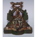 A Victorian polychrome painted cast iron door stop, in relief with Green Man mask and entwined