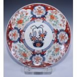 A large Japanese Imari charger, painted with a basket of chrysanthemums within blue trellis border
