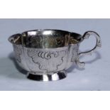 An 18th century Russian silver lobed oval vodka tot, cast and chased with flowering C-scrolls,