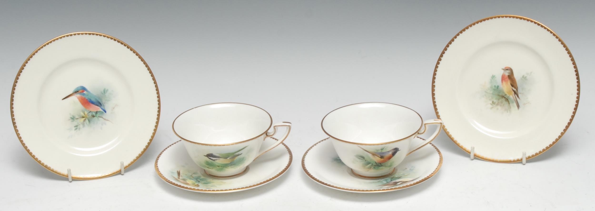 A pair of Royal Worcester teacups, saucers and side plates, painted by D Jones, signed, with