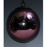 A late 19th/early 20th century iridescent pink glass witches ball, metal hanging pendant, 15cm diam