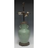 A Chinese celadon baluster vase, incised with flowers and leafy foliage, twin ring handles, later