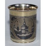 A Russian silver-gilt and niello beaker, decorated with architectural scenes, within oval reserves