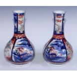 A pair of Japanese Imari ovoid bottle vases, painted with alternating panels of fanciful birds