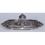 A Victorian electro-type inkstand, in relief with strapwork, fruiting vine and shells, glass well,