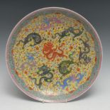 A Chinese circular charger, painted in polychrome with eight dragons amongst scrolling clouds, on