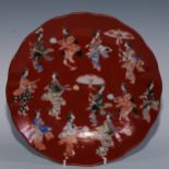 A Japanese Arita porcelain shaped circular charger, painted in polychrome with musicians on a