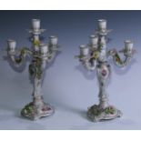 A pair of Dresden five-light candelabra, painted and encrusted with flowers, picked out in gilt,