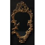 A 19th century Rococo Revival giltwood and gesso cartouche-shaped looking glass, the mirror plate