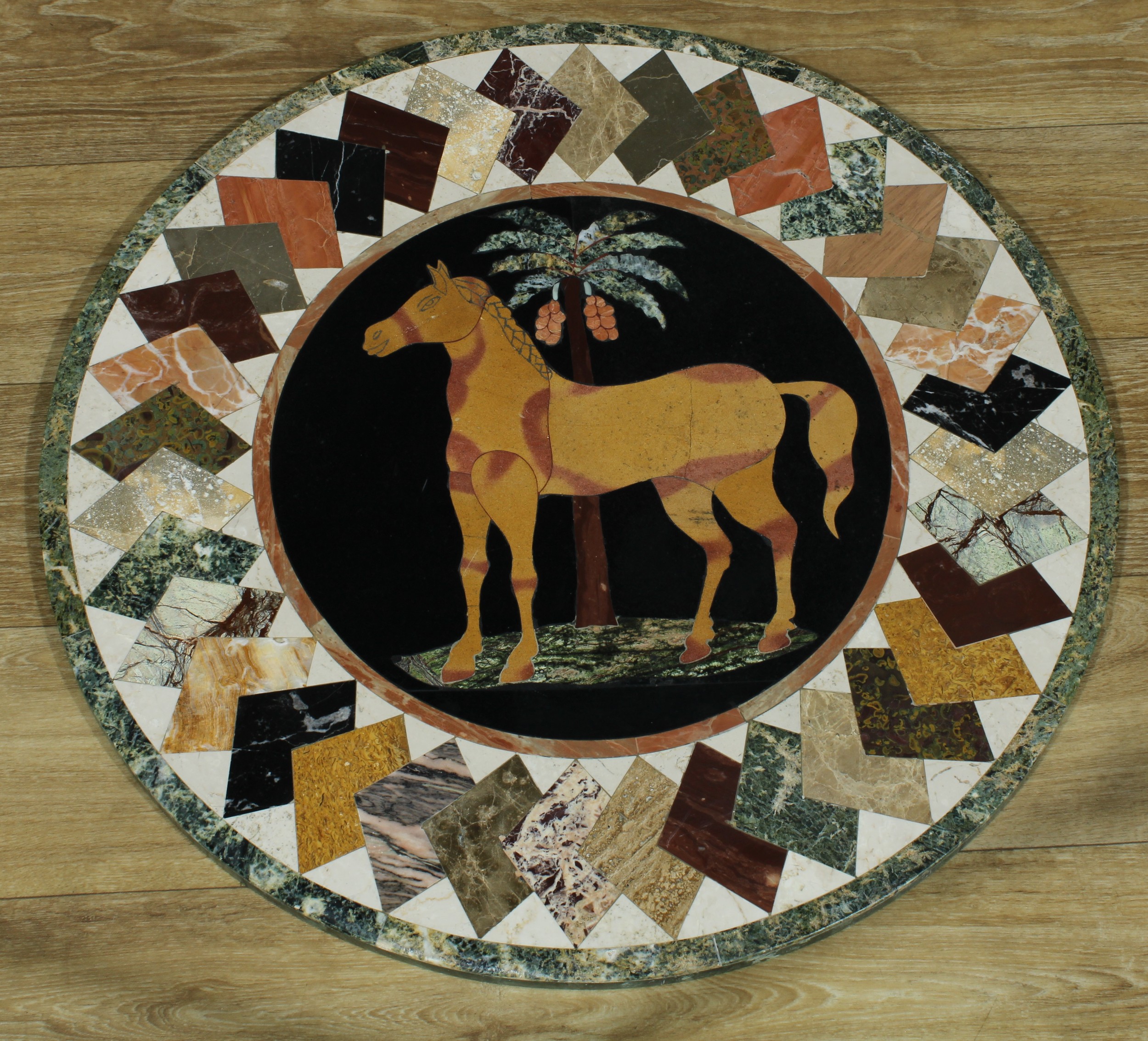 A pietra dura circular table top, inlaid in specimen stones with a horse within a band of layered