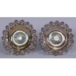 A pair of American silver shaped circular dishes, flower, leaf and tendril border, 13.5cm diam,