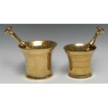 A 19th century flared cylindrical brass pestle and mortar, 12cm high; another, smaller, 11cm high (