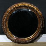 A 19th century circular softwood and gesso looking-glass, bevelled mirror plate outlined by a beaded