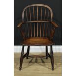 A 19th century elm Windsor elbow chair, low hoop back, bowed mid rail, turned arm posts, saddle