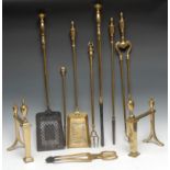 A set of three brass fire side implements, early 20th century; a pair of andirons, urn finials, 31cm