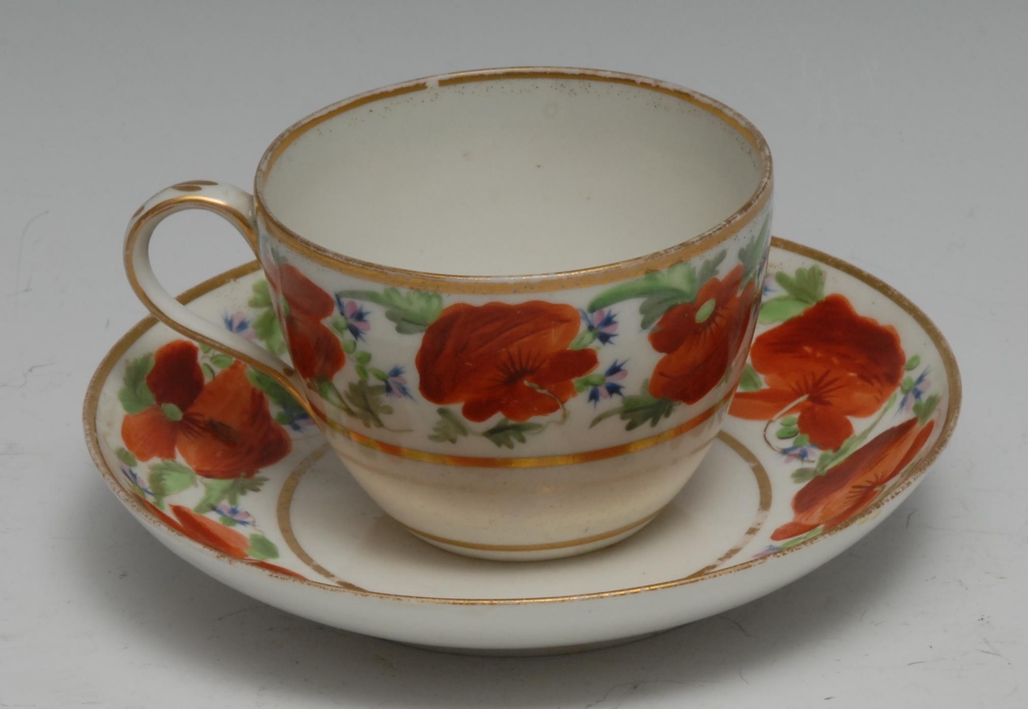 A Pinxton Bute shaped teacup and saucer, pattern 104, decorated with deep band of poppies, foliage