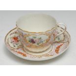A Pinxton fluted teacup and saucer, pattern 245, painted in polychrome with oval floral medallions