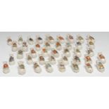 Forty crested ware pigs, seated, each with town crest in polychrome, various markers