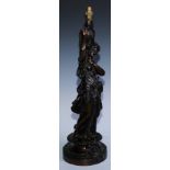 A late 19th century bronze figural table lamp, inspired by the antique, she stands holding a