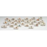 Thirty crested ware pigs, standing, each with town crest in polychrome, various markers