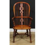 A 19th century Yorkshire elm Windsor elbow chair, hoop back, shaped and pierced 'Christmas tree'