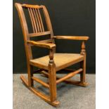 A 19th century childs rocking chair, shaped rail, rush seat, shaped arms, turned stretchers, 68.