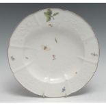 A Chelsea Gotzkowsky-type shaped and lobed circular plate, painted with scattered flowers and winged