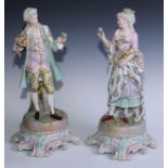 A pair of large 19th century Dresden figures of flower sellers, standing holding sample blooms, he