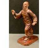A Chinese carved wooden figure, as an elderly bearded man, walking with arms in motion, integral