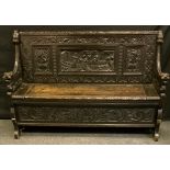 A late 19th/early 20th century Gothic Revival Dutch style oak Monks bench, carved three panel