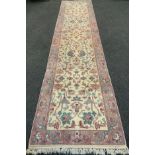 A Persian Sarough runner carpet, woven in subdued tones of pink, turquoise, and cream, 364cm x 82cm.