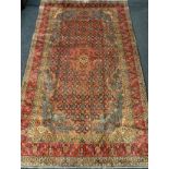 A fine Persian Tabriz rug / carpet, woven in shades of red, pale blue, and indigo, 350cm x 215cm.