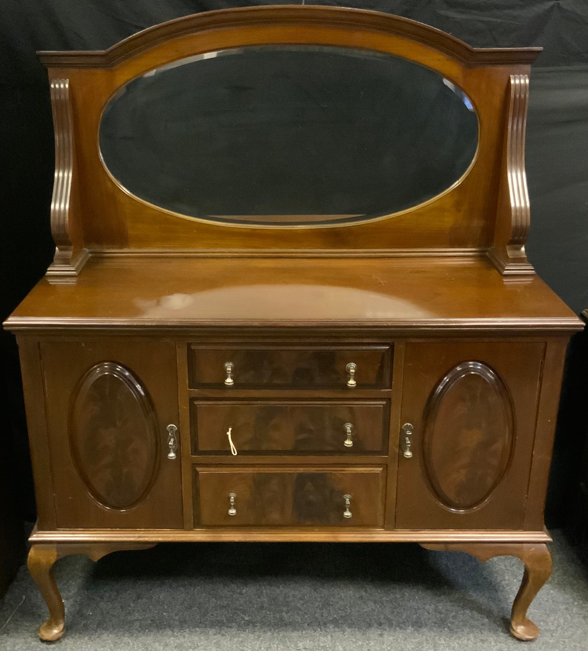 A Queen Anne style mahogany mirror back sideboard, an oval bevelled mirror, the slightly over