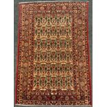 An antique Persian, hand-made Malayer rug / carpet, the margin of deep red and blue enclosing a