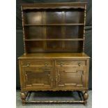 An early 20th century oak dresser, two tiers of shelving above two drawers and cupboard doors,