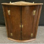 A George III oak wall hanging corner cupboard, 86cm high, 74cm wide.