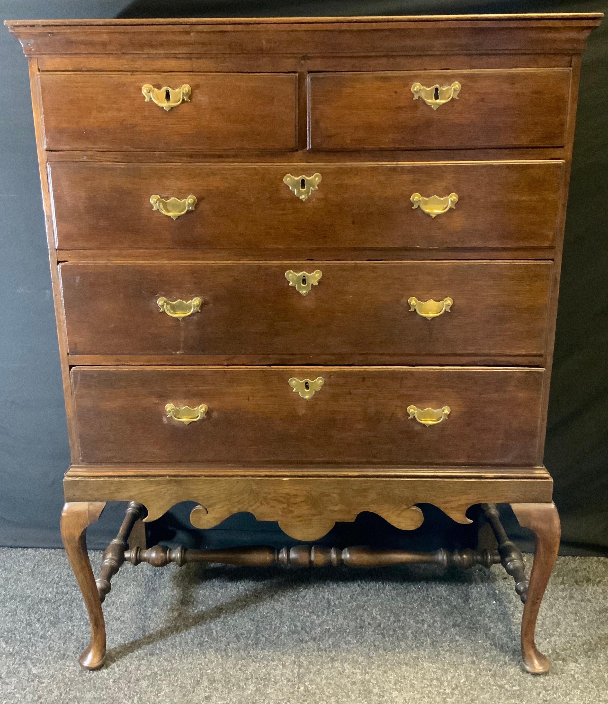 A George III oak chest on stand, rectangular top above two short and three long graduated drawers,