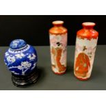 A pair of Japanese Kutani cylindrical vases, decorated in the typical palette with Geisha and man of