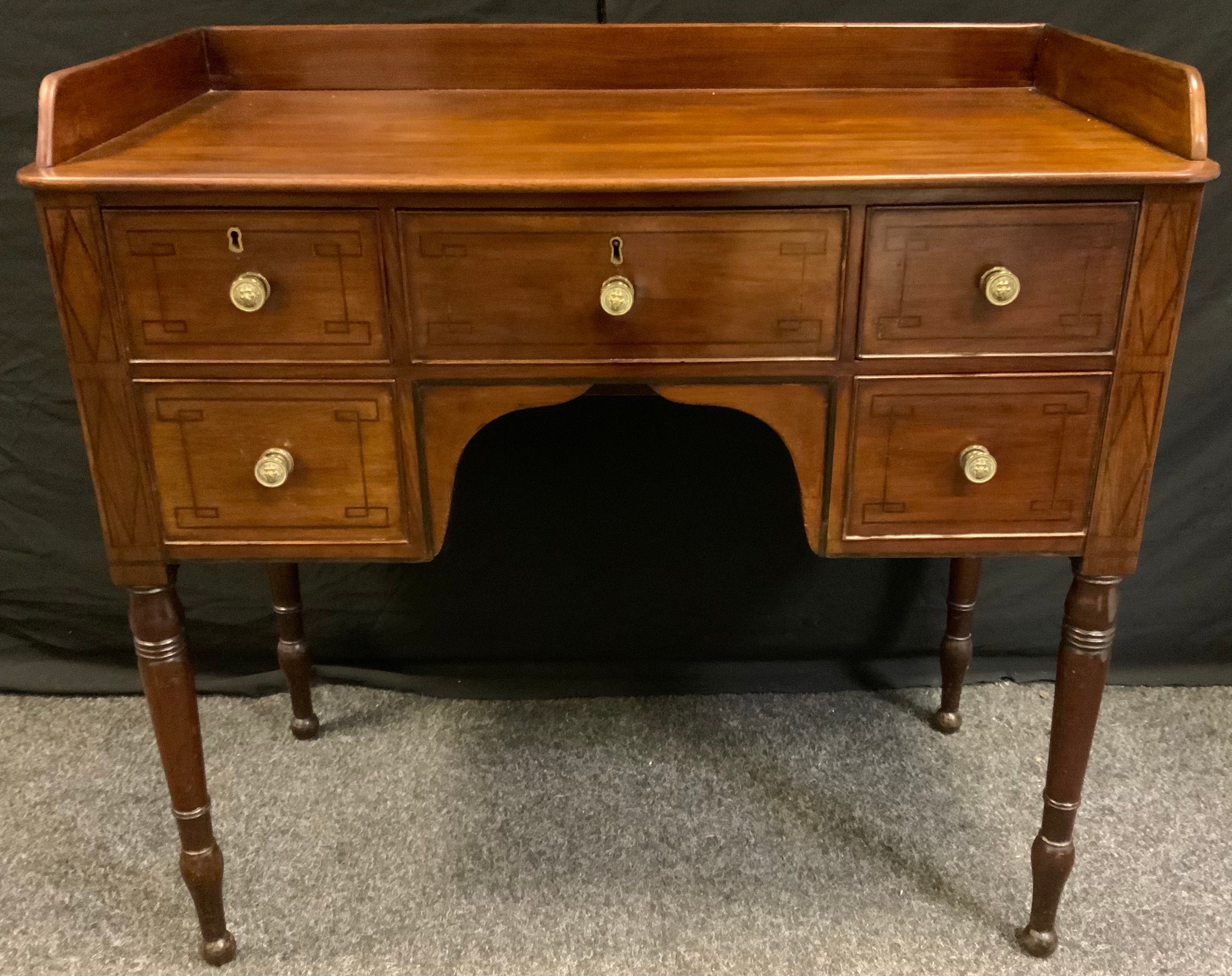 A George III style mahogany knee-hole desk, three quarter gallery rectangular top above a central