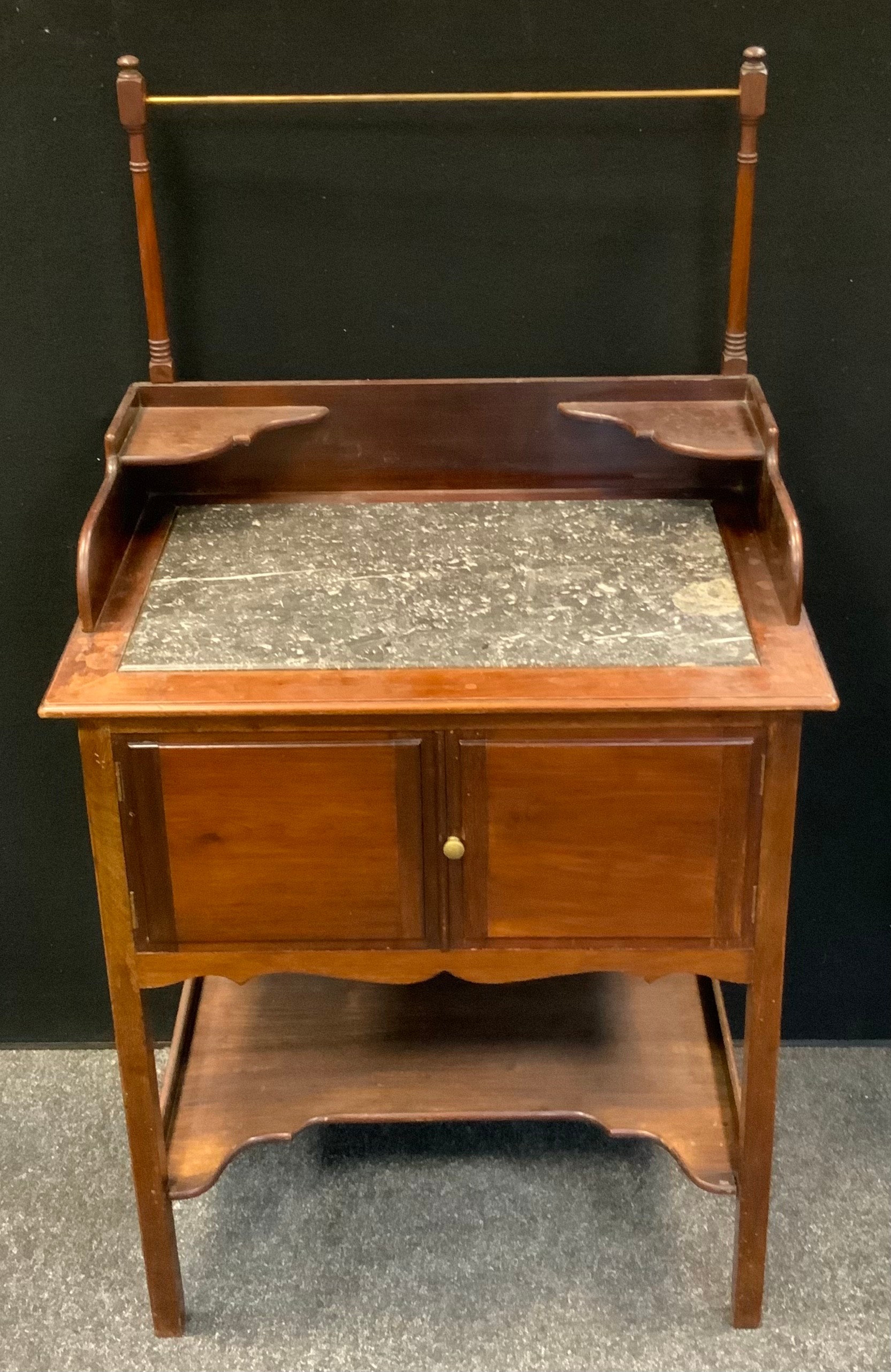 A late Victorian mahogany wash stand, the top inset with a fossil stone/marble surface, above a pair