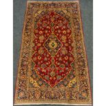 A fine Persian Kashan rug / carpet, profusely woven with styled flowers and leaves, in shades of