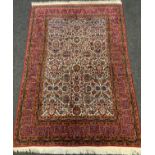 A fine hand-made Kashan rug / carpet, the margin of deep red and blue enclosing a central field