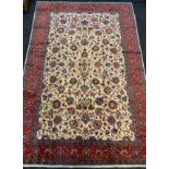 A fine Kashan rug / carpet, woven in shades of red, cream, and blue, 310cm x 205cm.