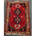A 20th century Persian Shiraz rug, central row of medallions within floral field, four section