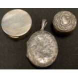 A silver pill box; another; a silver locket